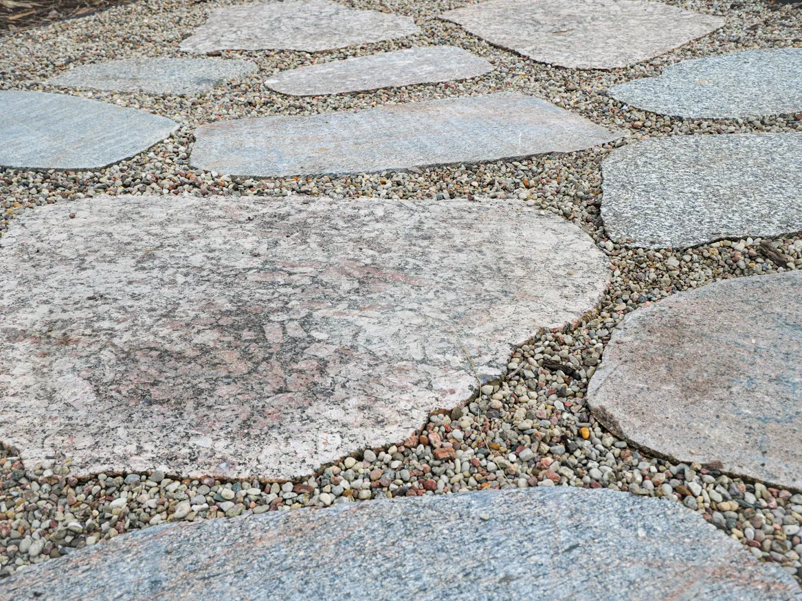 Ścieżka z plastrów kamiennych z fugami wypełnionymi żwirem.