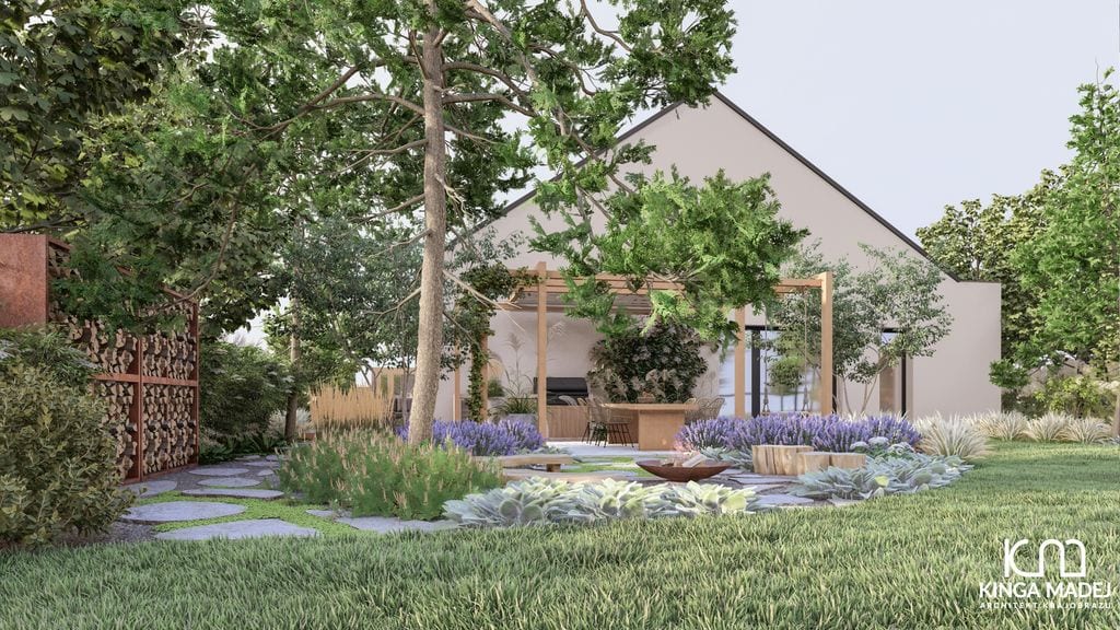 Widok na strefę ogniska otoczoną roślinnością bylinową i trawami. Cortenowa szafa na drewno