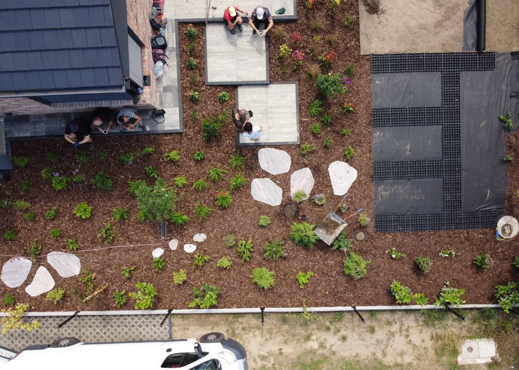 Zdjęcie z drona pokazujące etap budowy. Ogrodnicy w trakcie przerwy na kawę.